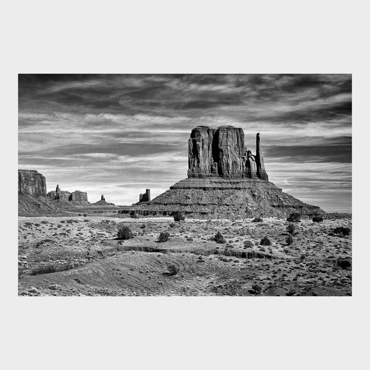 Black and white photograph of a desert landscape with prominent rock formations. Monument Valley, Utah, Arizona