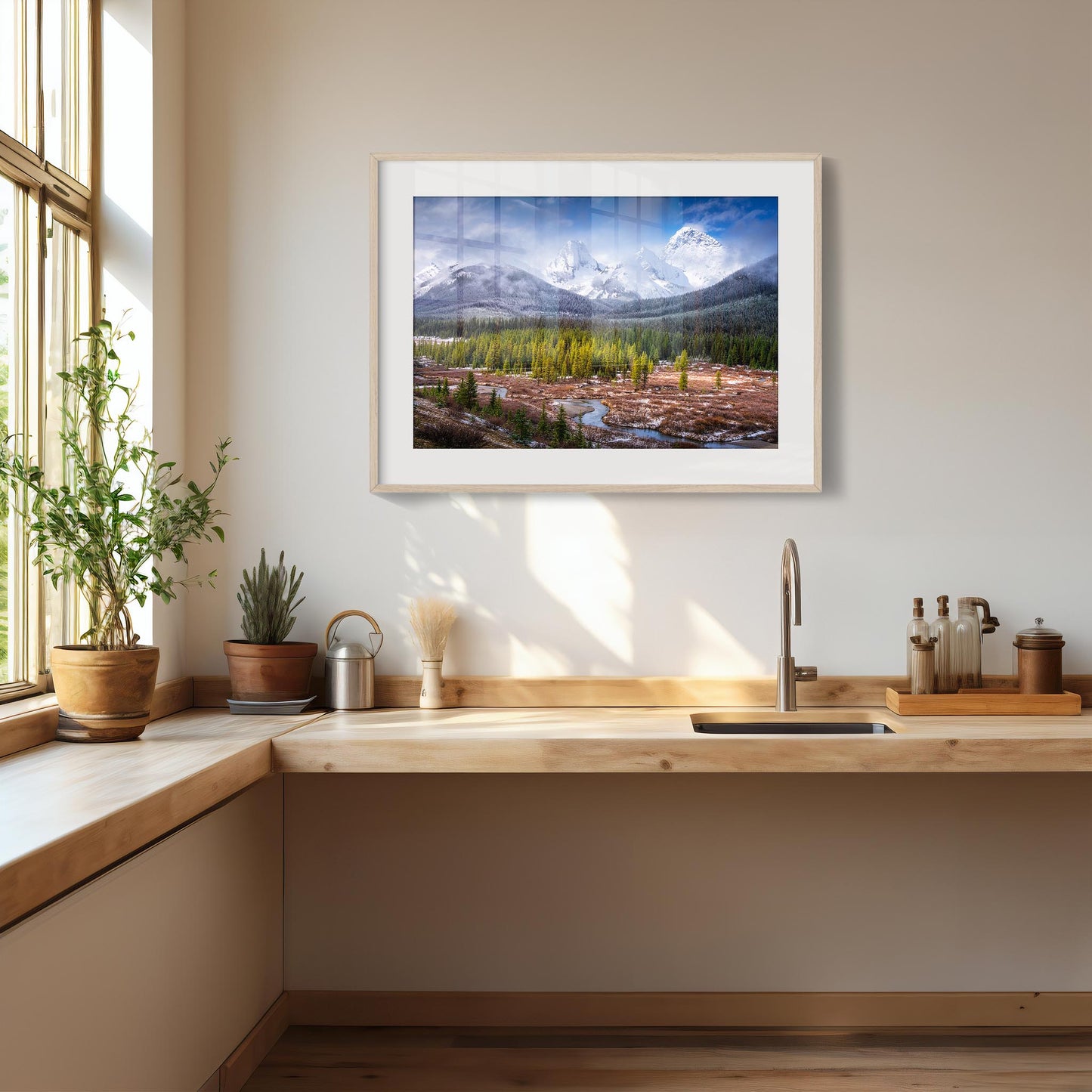 Framed landscape print above a kitchen counter with plants and kitchen items. Spray Valley, Kananaskis Country, Alberta, Canada, Rocky Mountains