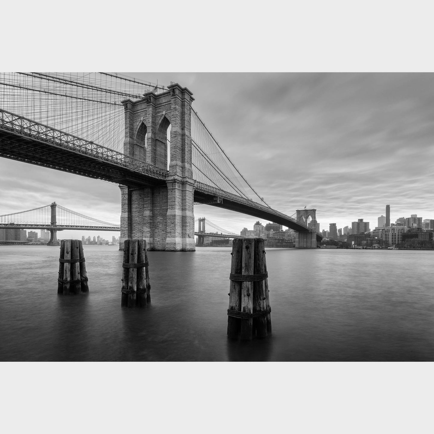 Black and white photograph of the Brooklyn Bridge with a city skyline in the background. East River Reverie, New York, Fine Art Photography, Limited Edition, Dermot O'Kane.  Beautiful fine art landscape photography wall art limited edition prints for sale.