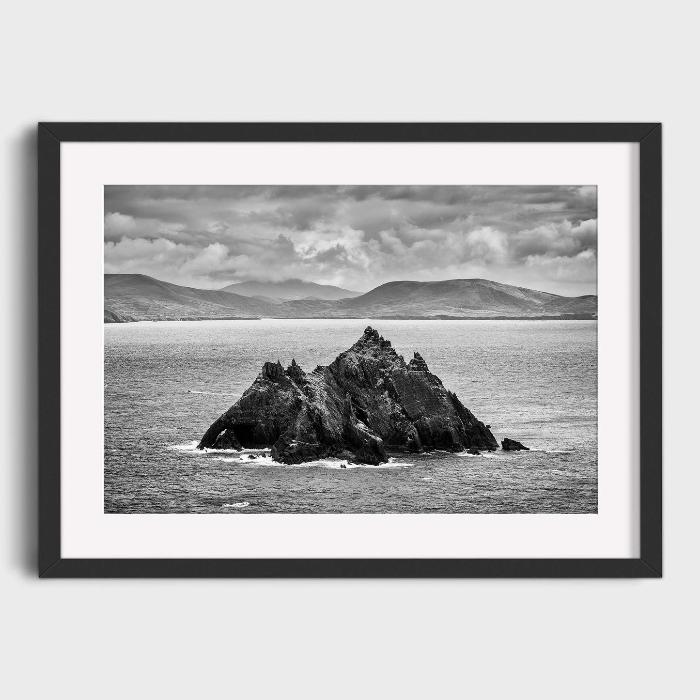Framed black and white photograph of a rocky island in the ocean with mountains in the background. Little Skellig, Co. Kerry, Ireland, Luke Skywalker, Star Wars Island, Beautiful fine art landscape photography wall art prints for sale. Dermot O'Kane
