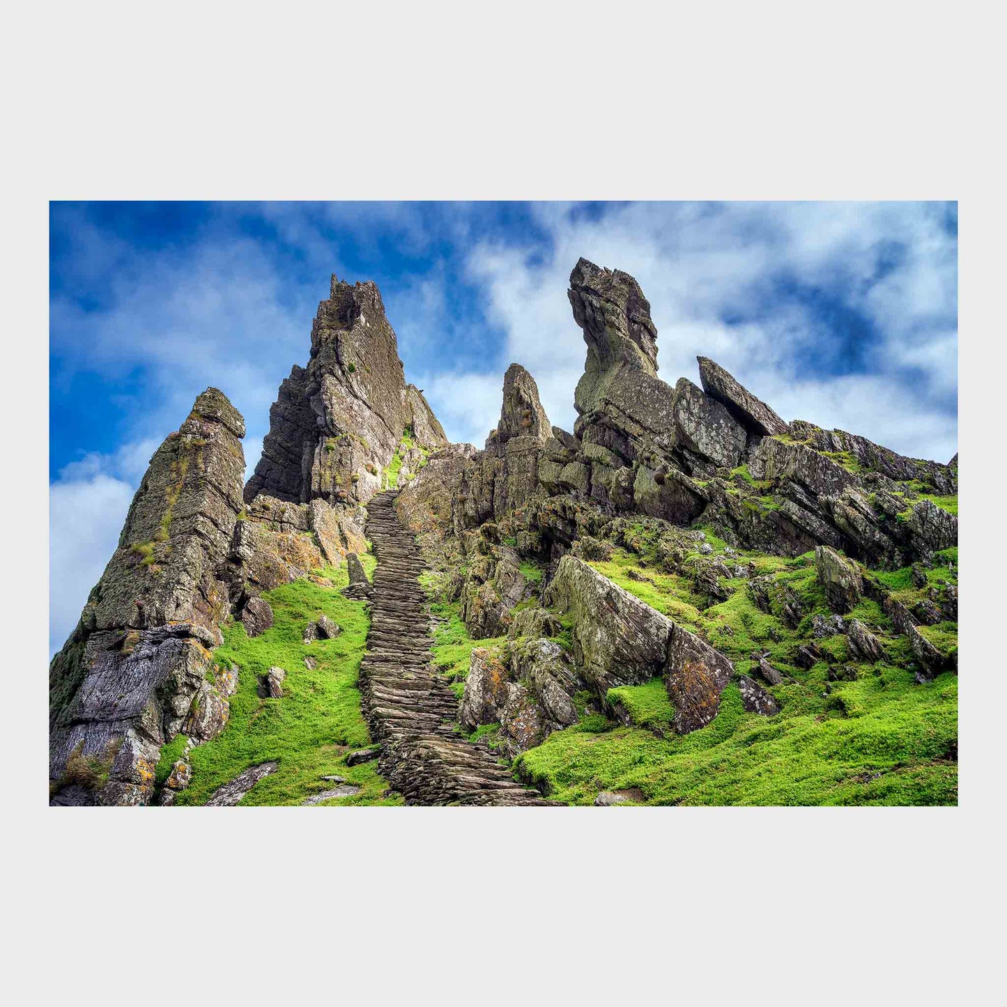 Rocky landscape with ancient stone steps leading up a grassy hill under a blue sky. Skellig Michael Steps, Co. Kerry, Ireland, Luke Skywalker, Star Wars Island
