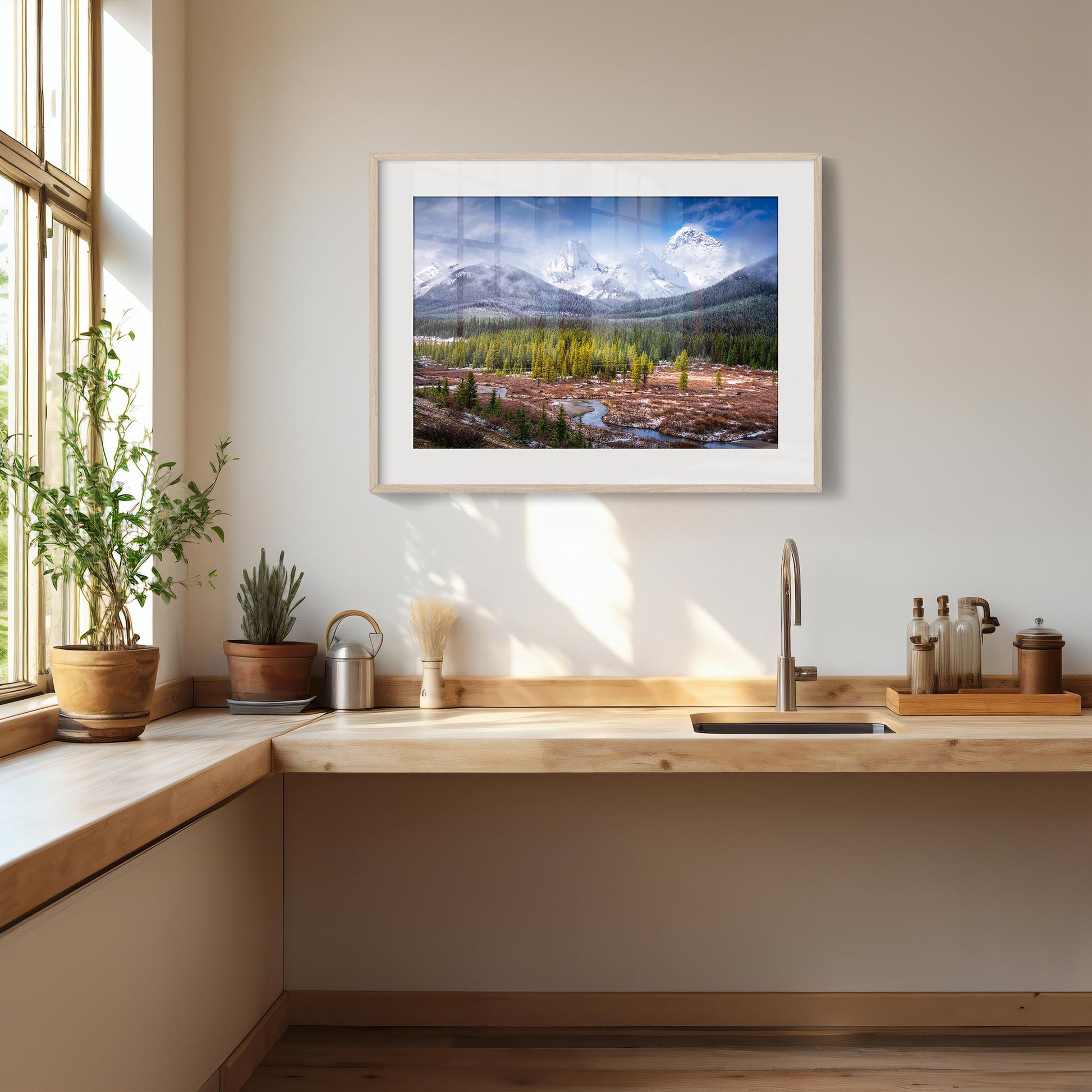 Framed landscape print above a kitchen counter with plants and kitchen items. Spray Valley, Kananaskis Country, Alberta, Canada, Rocky Mountains